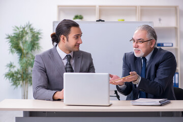 Obraz premium Old and young businessmen in business meeting concept