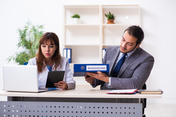 Young female doctor and sick businessman in the office