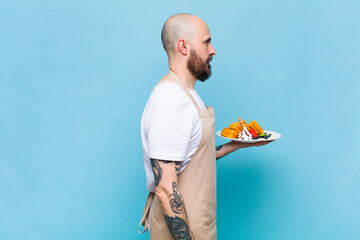 bald man on profile view looking to copy space ahead, thinking, imagining or daydreaming