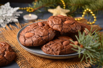 Obraz na płótnie Canvas Chocolate cookies with almonds are on a plate, festive surroundings.