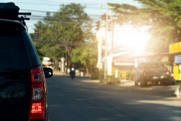 Rear side of black car travel to upcountry. Stop on the asphalt road.  with rural urban environment.