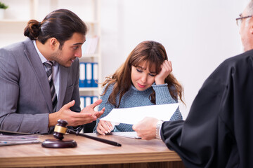 Young woman in courthouse with judge and lawyer