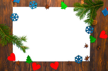 Christmas background with a white sheet of paper for copy space text and design wooden decor in the shape of a heart and snowflakes