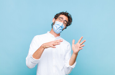 young bearded man with cheerful, carefree, rebellious attitude, joking and sticking tongue out,...