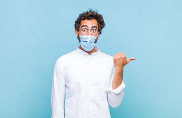 young bearded man looking astonished in disbelief, pointing at object on the side and saying wow,...