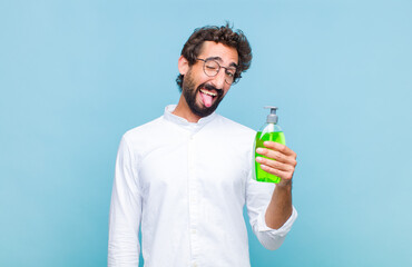 young bearded man with cheerful, carefree, rebellious attitude, joking and sticking tongue out,...