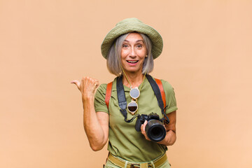 middle age woman looking astonished in disbelief, pointing at object on the side and saying wow,...