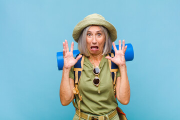 middle age woman screaming with hands up in the air, feeling furious, frustrated, stressed and upset