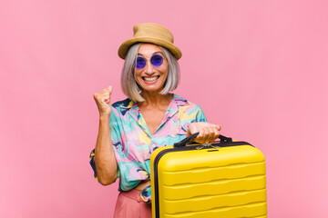 middle age woman feeling shocked, excited and happy, laughing and celebrating success, saying wow!