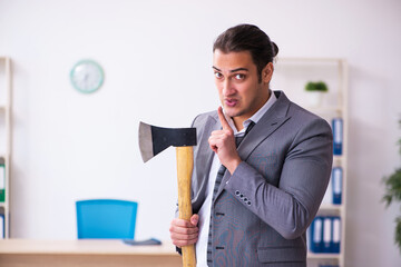 Young employee angry with excessive work holding hatchet