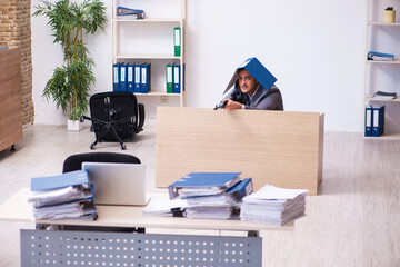 Young employee angry with excessive work holding firearm weapon