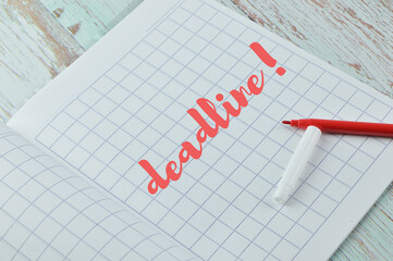 Top angle view of red color pen and math book written with text DEADLINE!. Business and education. 
