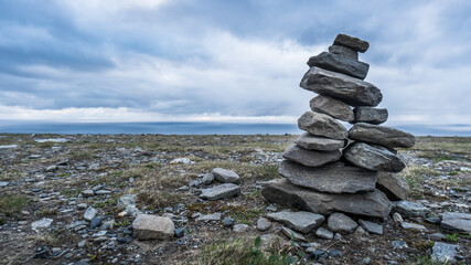 Good luck cairns made of stones in Norway under dramatic sky