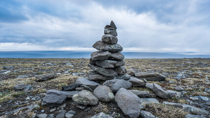 Good luck cairns made of stones in Norway under dramatic sky