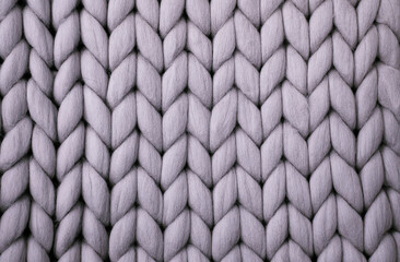 Fototapeta premium Light grey knitted background. Woolen fabric with pattern of braids. Neutral background of drawing.