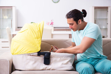 Young male parent looking after newborn at home
