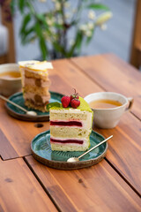 afternoon tea on the roof terrace. assorted cakes and fresh green tea in a teapot on a wooden table