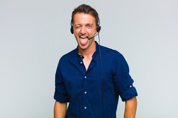 young handsome man with cheerful, carefree, rebellious attitude, joking and sticking tongue out,...