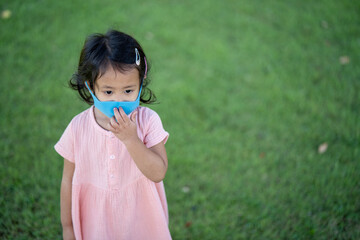 Fototapeta premium Cute little girl walking outdoor wearing healthy face mask prevent virus and PM2.5