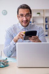 Young male bookkeeper calculating tax payments in the office