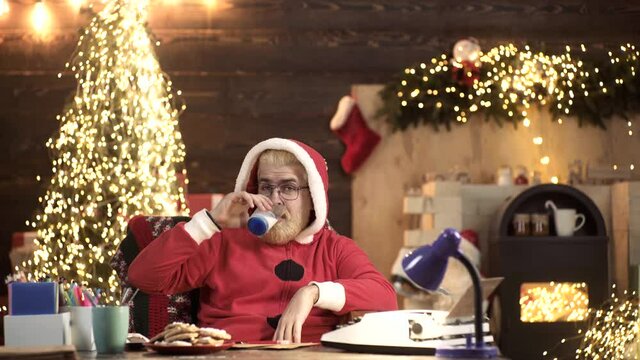 Crazy Repper Santa Claus sing rap or Hip Hop and drink milk at home near Christmas tree. Funny New Year Holiday.