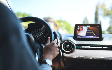 Closeup image of a woman holding steering wheel while driving a car on the road