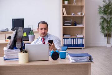 Young male employee in time management concept