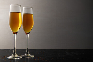 Two glasses of champagne, wine on a gray background, a place for text on the right, copypace. New year and Christmas background