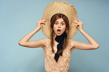 Romantic girl in a straw hat on a gray background and a beige sundress black ribbon emotions model