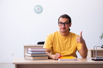 Young male student physics preparing for exams in the classroom