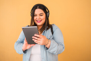 Woman listening music with headphones and tablet.