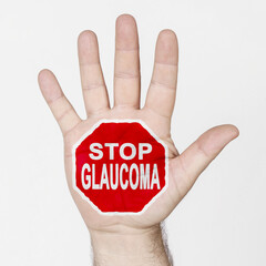 On the palm of the hand there is a stop sign with the inscription - STOP GLAUCOMA. Isolated on...