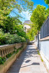 Paris, France, famous pink house and buildings in Montmartre, in a typical street
