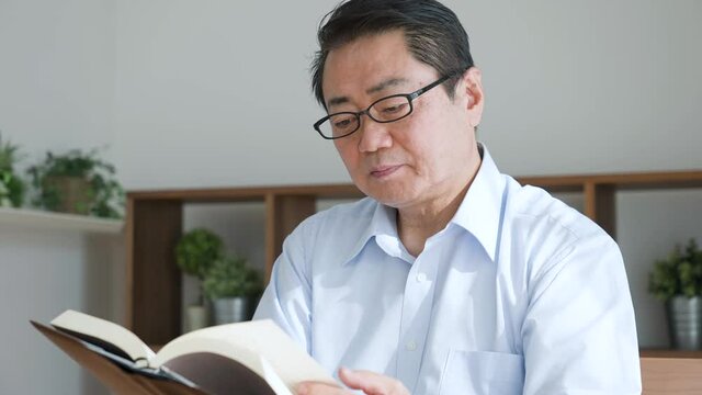 本を読んでいる中年男性