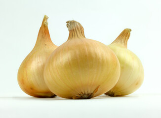 Three yellow organic onions on white background.