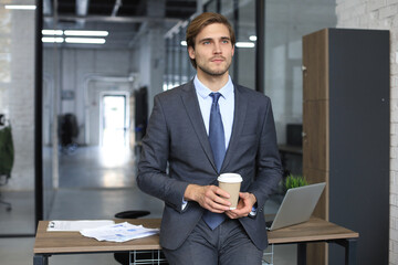 Portrait of young man sitting at his desk in the office.
