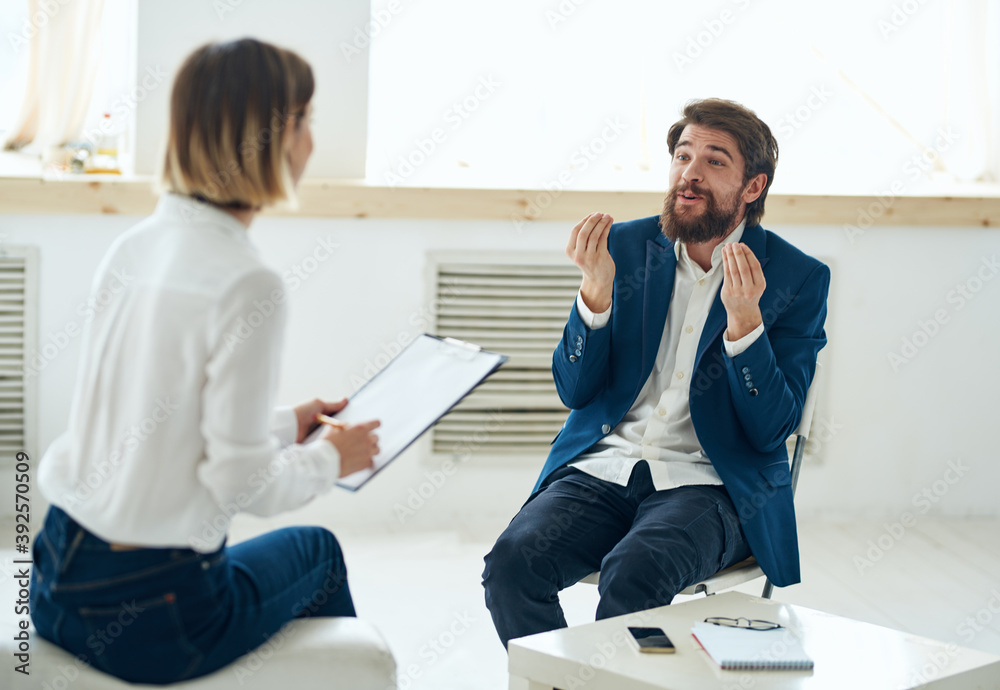 Wall mural a man explains something to a woman to a psychologist indoors near a window