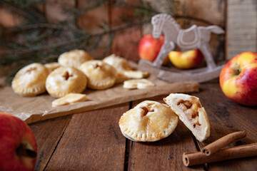 Handkuchen gefüllt mit Äpfeln und Zimt auf einem Tisch aus Holz in der Küche zur Weihnachtszeit