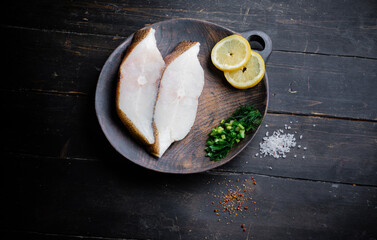 Frozen Greenland halibut steaks on the wood cutting board. Food background. Top view