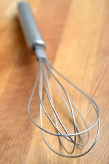 stainless steel whisk on a wooden table