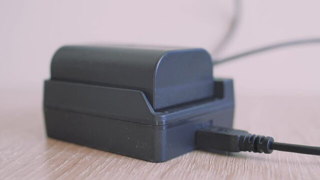 Man hand instaling battery on black charger