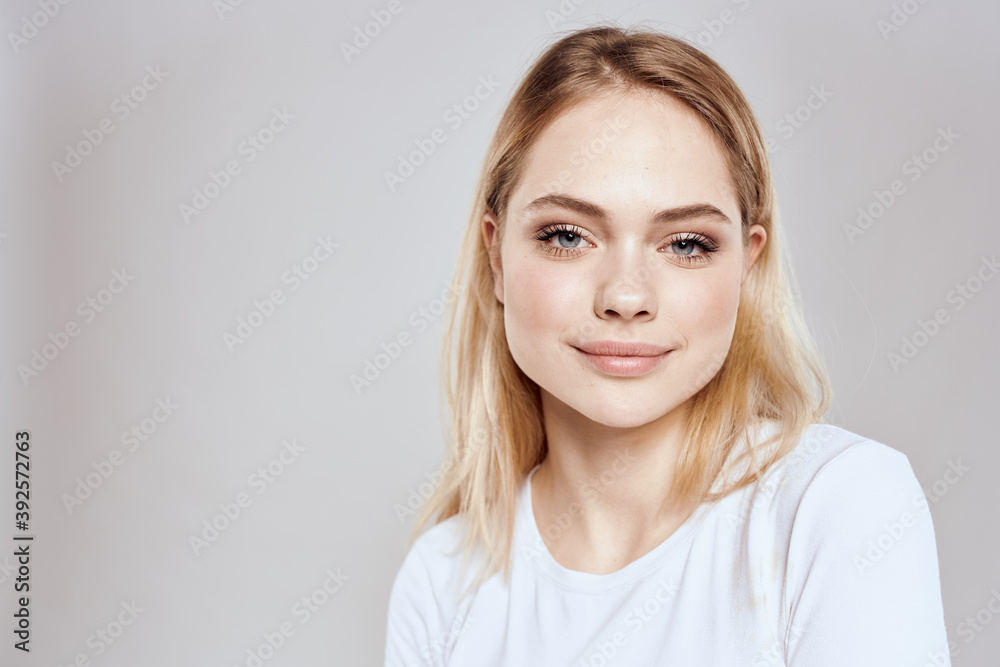 Canvas Prints Cheerful blonde woman in white t-shirt cropped view light background