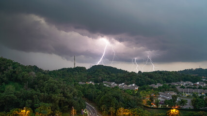 Lightning storm over a hill with 5G Comm Tower