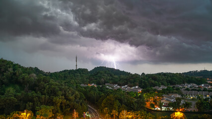 Lightning storm over a hill with 5G Comm Tower