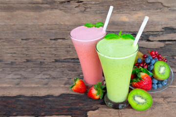 Kiwi and strawberry smoothies fruit juice green and red beverage healthy the taste yummy In glass drink episode morning on wooden background.
