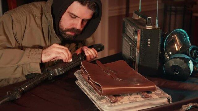 prepper guy cleaning gun next to radio