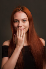 portrait of a beautiful red haired young positive woman in studio
