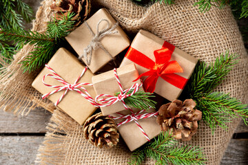 Christmas gift boxes in ecofriendly craft paper. Gifts in a wooden box on a wooden table. Eco-friendly gift packaging