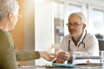 Obraz premium Mature practitioner in office listening to patient