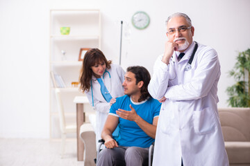 Obraz na płótnie Canvas Two doctors visiting sick young man at home